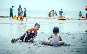 Pengunjung bermain air di pantai